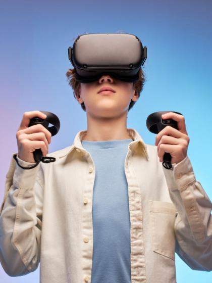 Ragazzo con visore VR e controller, immerso nella realtà virtuale.