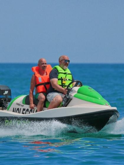 Due uomini su una moto d'acqua indossano giubbotti di salvataggio colorati.